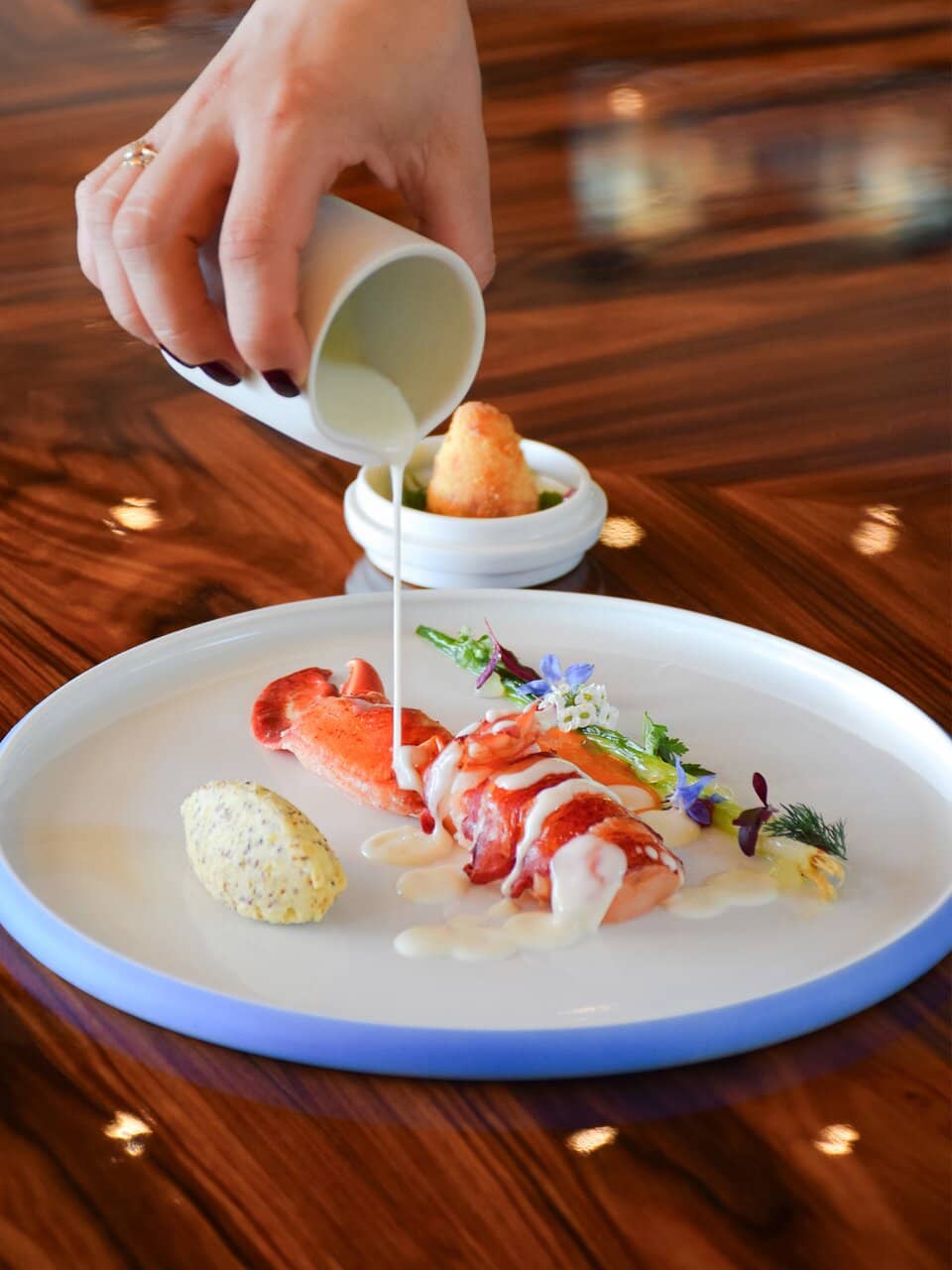 Astice, mozzarella di bufala affumicata, patata alla senape e cipollotto arrosto