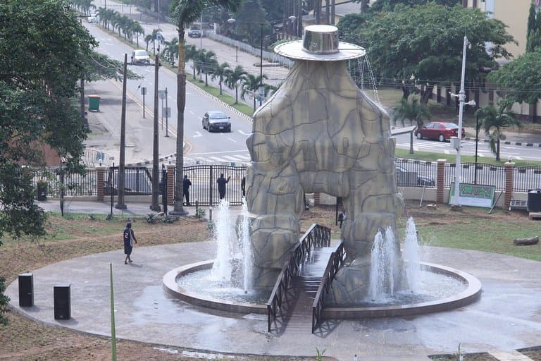 Eyo statue flanked with water fountain