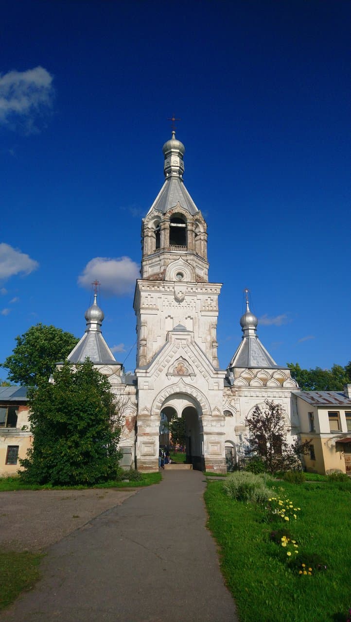 Десятинный монастырь. Десятинный монастырь. Колокольня постройки 1902-1903 года. Называется это "восьмерик на четверике", а более подробно вот так. На высоком четырехугольном основании (четверике) с проездными воротами поставлен восьмигранник (восьмирик) с восемью пролетами для колоколов, который завершен восьмигранным шатром, увенчанным шейкой сложной формы и маленькой главкой с крестом. К колокольне с двух сторон примыкают часовня и просфорня.