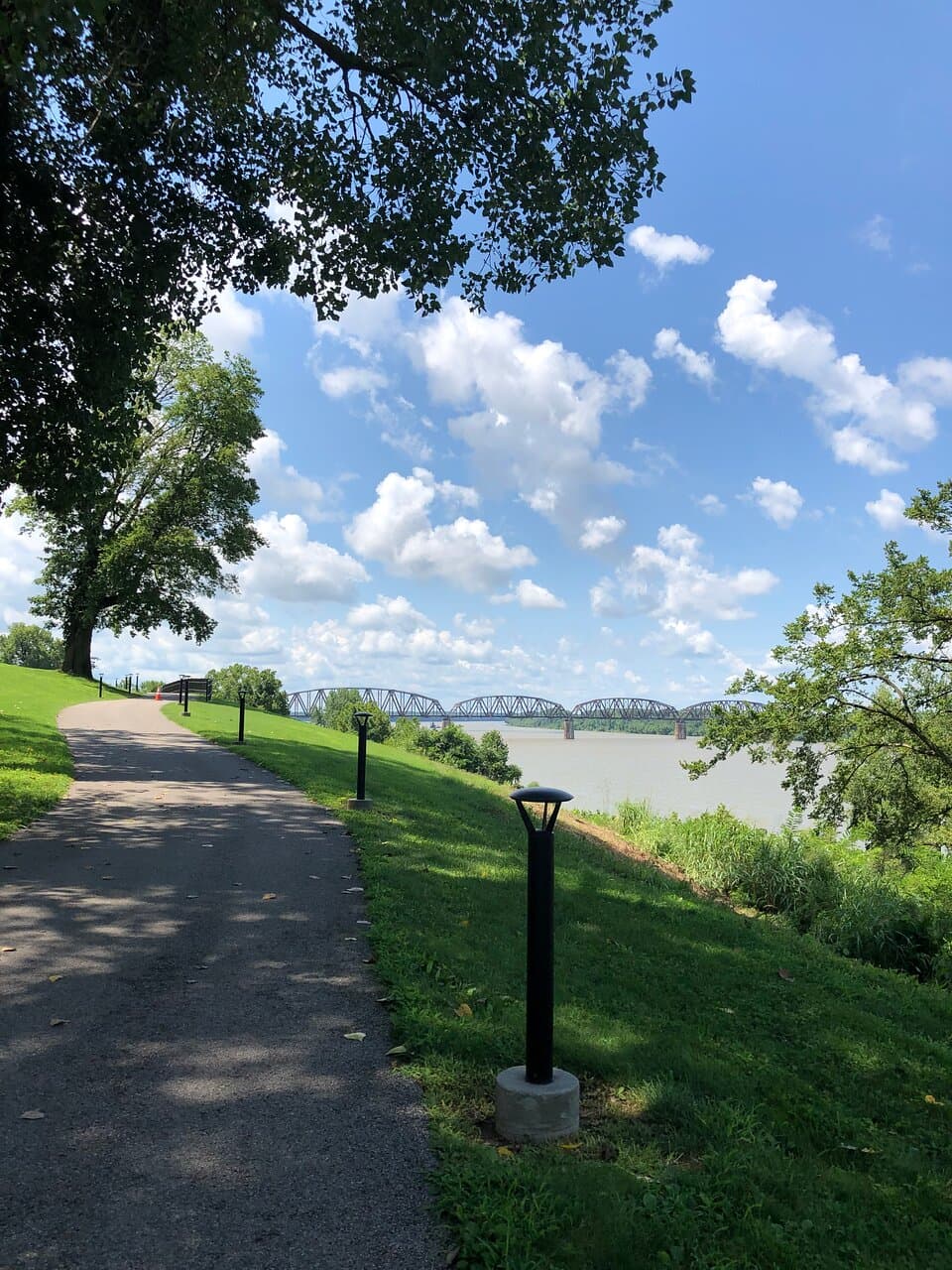 A stretch of the Henderson RiverWalk with the railroad bridge in the distance.