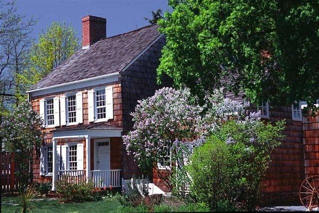 The Whitman Birthplace with lilacs in bloom.