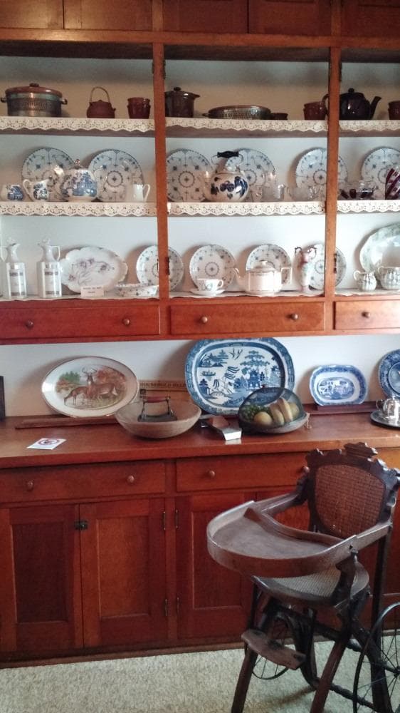 Kitchen has lots of storage and a vintage convertible highchair.