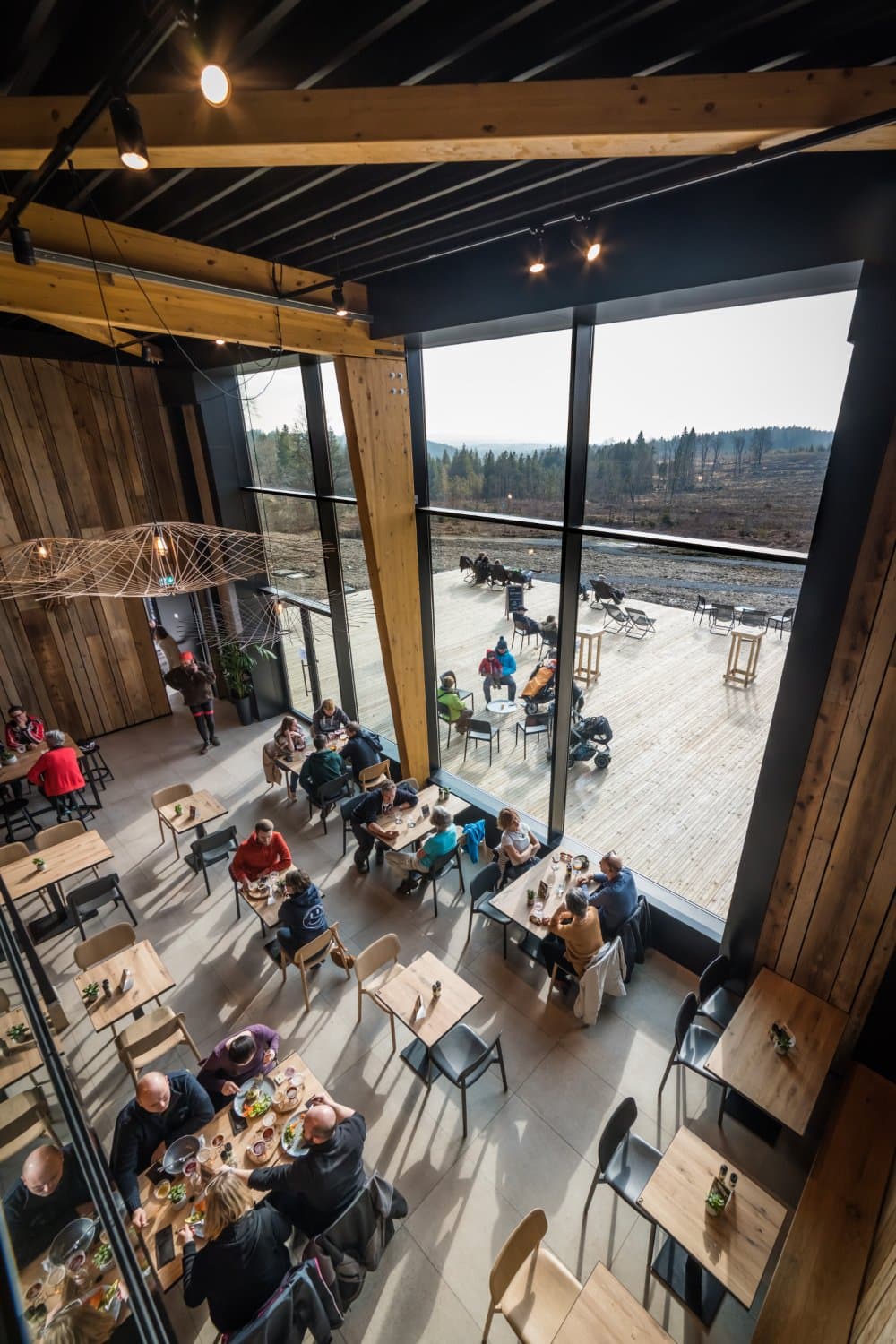L'espace intérieur avec la grande baie vitrée offrant une vue magnifique sur les Hautes Fagnes.