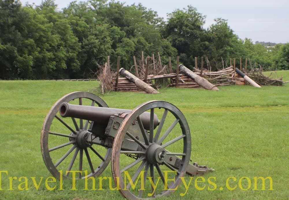 Cannon with log fence in the background