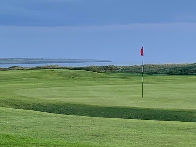 The 18th green with views out over Sinclair Bay.