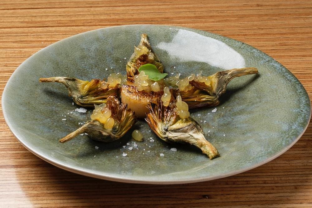 Alcachofas horneadas, viera plancha y caviar de lenteja. 