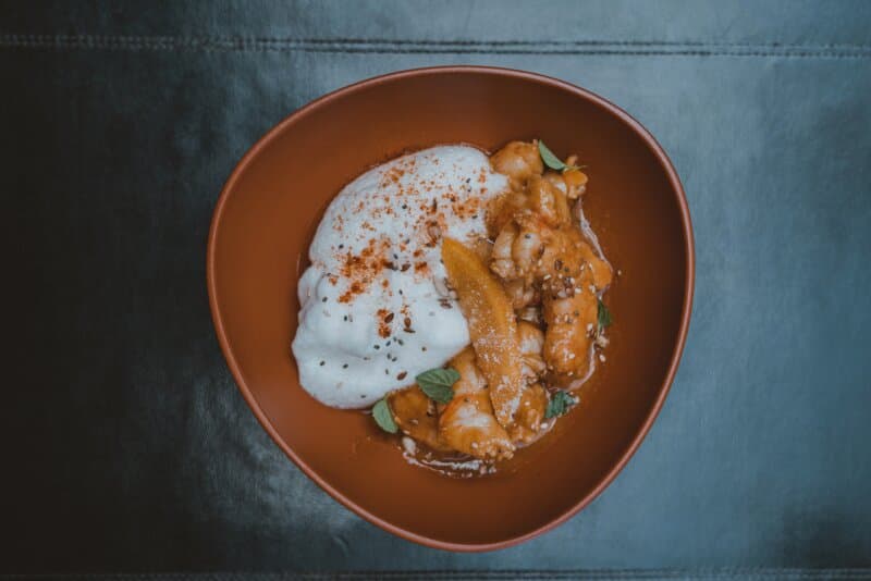 Langostinos en tempura, emulsión de pimiento verde,
criolla, malbec
