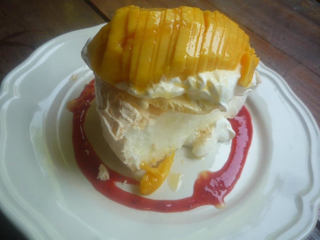 Fresh mango pavlova with strawberry sauce