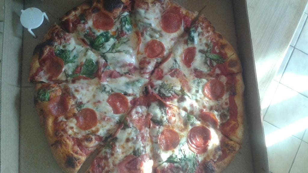 Pepperoni pizza with roasted garlic and spinach.