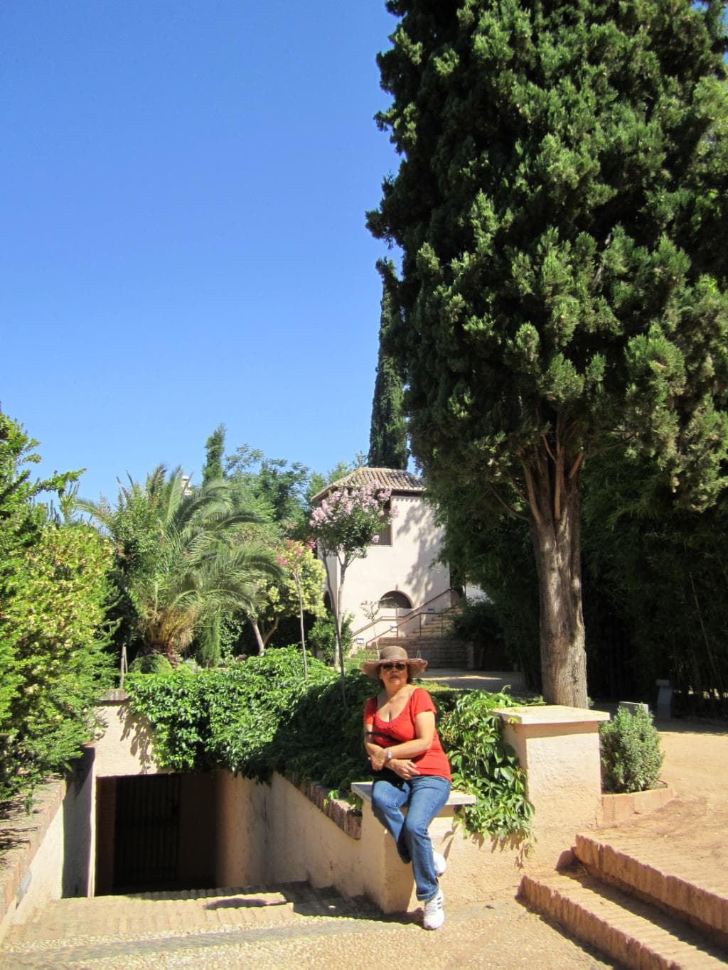 Mi esposa sentada sobre muro jardinera antes de ingresar a la Casa-Museo.