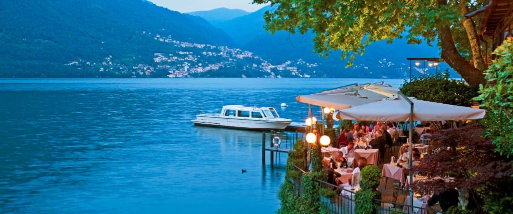 Giardino del Crotto dei Platani con vista del Borgo di Nesso dall'altra parte del Lago
