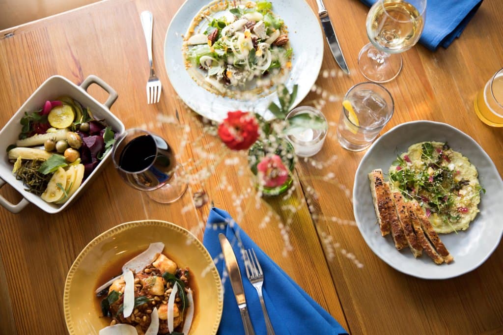 Table Spread. Pickles, hummus, salad, gnocchi. Photo by Andrew Sherman.