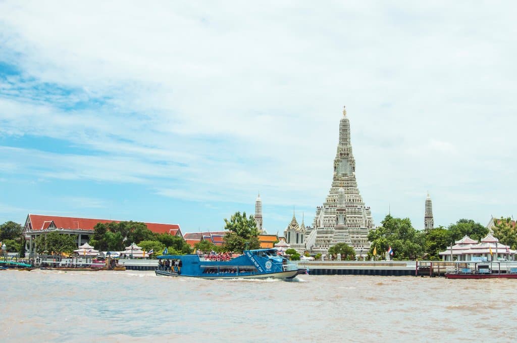 Chao Phraya Tourist Boat's double-decker boat passing the Temple of Dawn (Wat Arun)