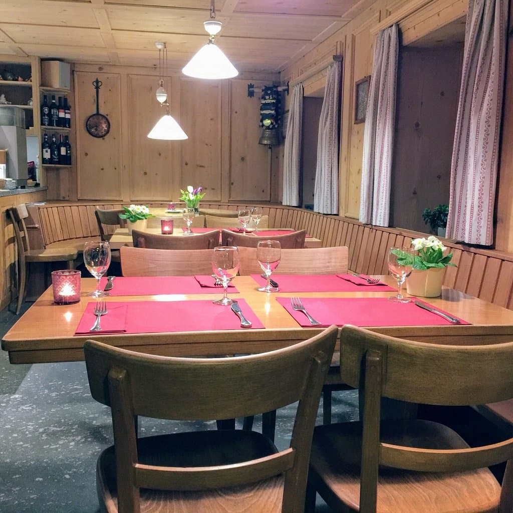 Eine Gaststube, in welcher in Kürze jeder Platz besetzt sein wird. Wo man Capuns essen geht und 