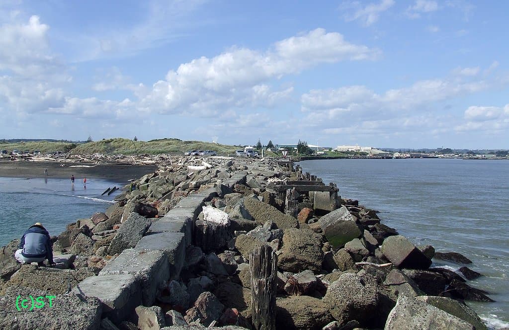 Breakwater rock split the river and the beach