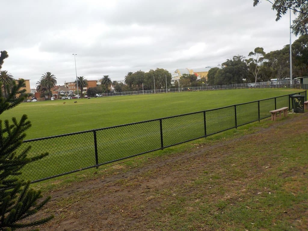 Much grass, some seats by the fence