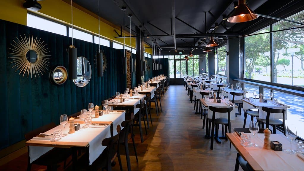 orienté plein sud la salle est lumineuse, chaleureuse et confortable. Les baies vitrées créées par la SCAN en 1959 ont la particularité d'être basculante. En 2018 le système entièrement rénové par la métallerie Tardy (17). Pour info la SCAN (La Rochelle) avait réalisée les 5000 fenêtre de la maison de la radio (Paris) en 1956.