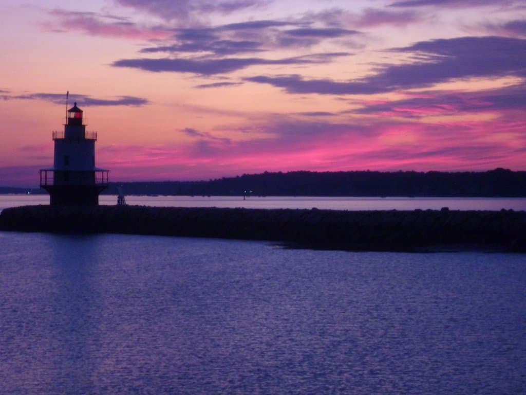 A summer dawn approaches Spring Point Ledge Lighthouse, as seen from Fort Preble in South Portland, Maine.