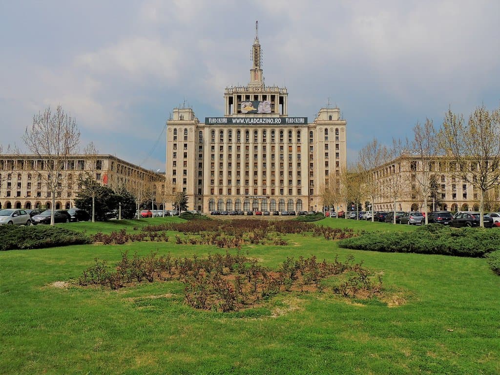 Front of building with little park and left and right wings, that are occupied by ministries and businesses.