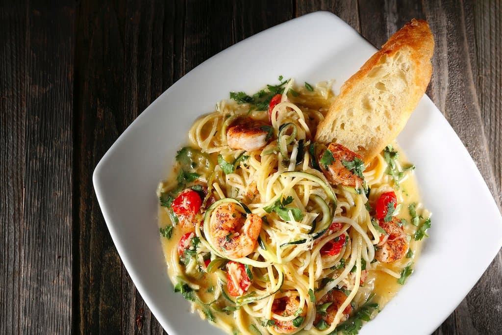 Scampi with pan seared shrimp, cilantro-lime butter, chilies, tomatoes, garlic and Parmesan over spaghetti and zucchini noodles with grilled Swamp Rabbit Stecca bread