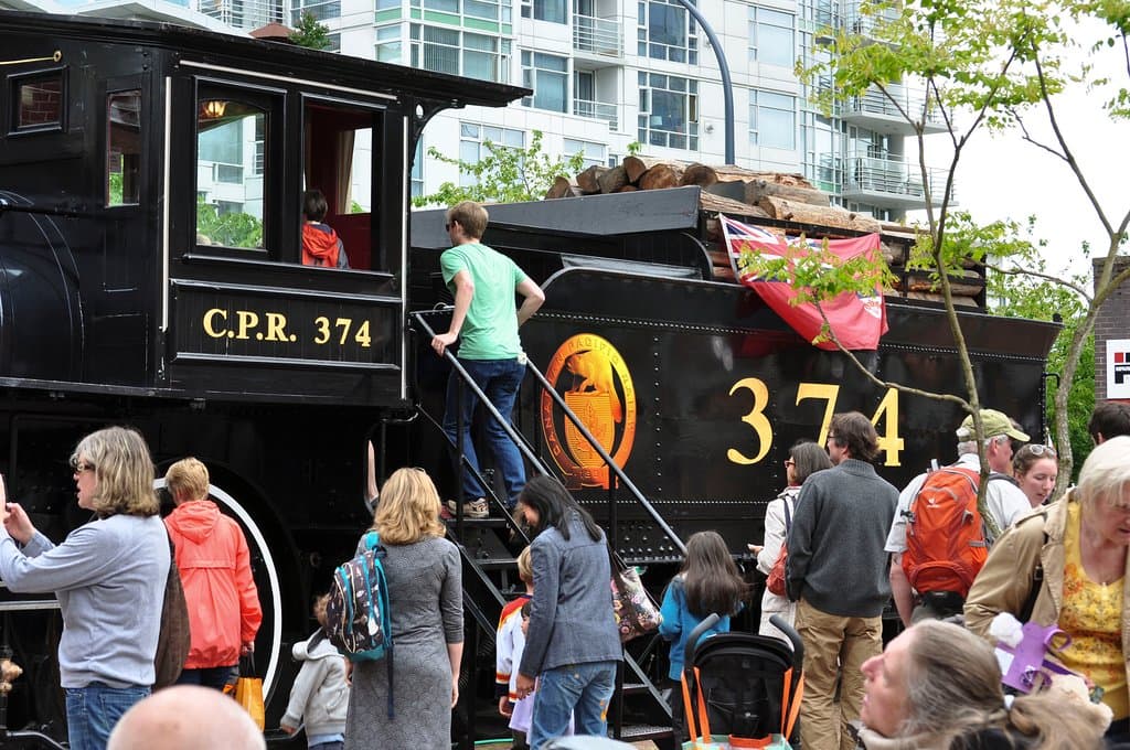 Climb aboard! Enthusiastic visitors climb into the Engine 374 cab which makes its annual pilgrimage onto the Roundhouse Turntable Plaza to celebrate its arrival in Vancouver on May 23, 1887. Photo by Barbarah Senez, 2013. 