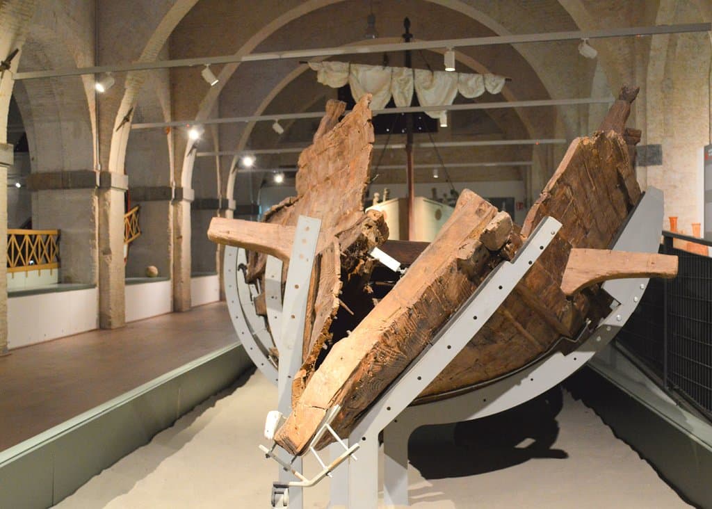 L'Alkedo, una nave privata, costruita però per assomigliare ad una nave da guerra: in primo piano l'imbarcazione originale del I secolo d.C. restaurata, sullo sfondo la sua ricostruzione, a grandezza naturale.