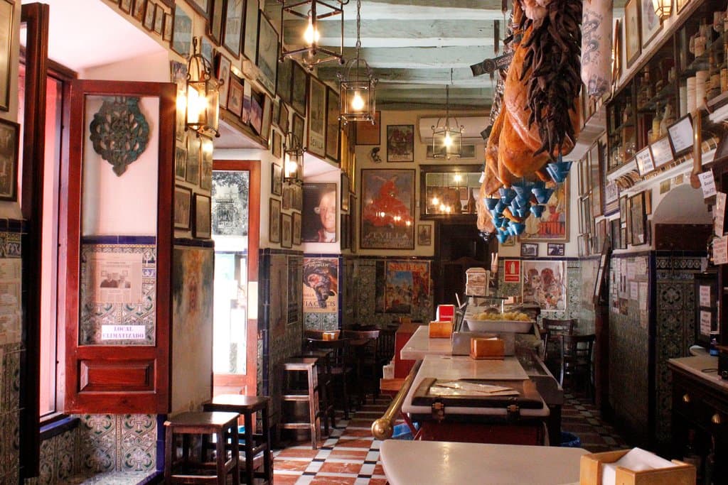 Nuestra propuesta de ibéricos de máxima calidad y guisos como las espinacas con garbanzos y el bacalao con tomate nos convierten en una visita imprescindible en Sevilla. 