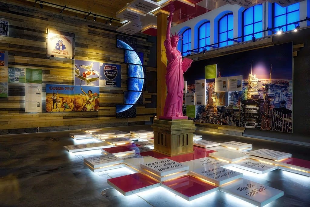 Im Raum der Ankunft erfahren die Besucher mehr über die Umstände der Ankunft der Auswanderer in New York. Mittelpunkt ist die pinkfarbene Freiheitsstatue, die für Freiheit, Aufbruch, Mut steht. Sie signalisiert durch ihre Farbe, dass die Welt bunt ist. 