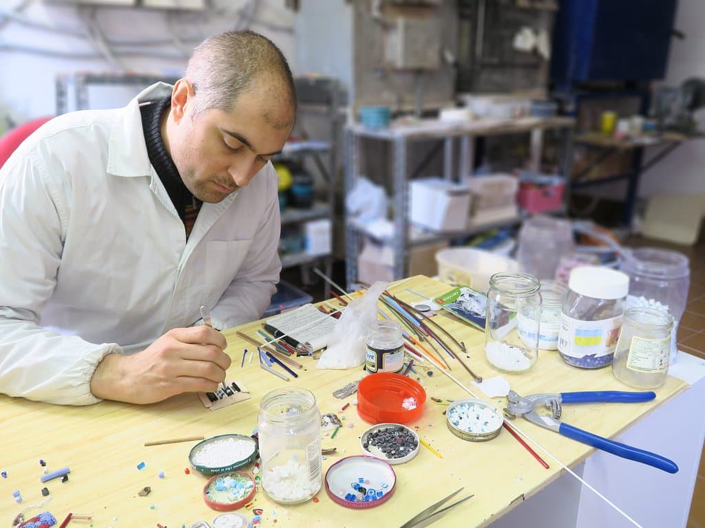Davide working with tweezers in the composition of a murrina.