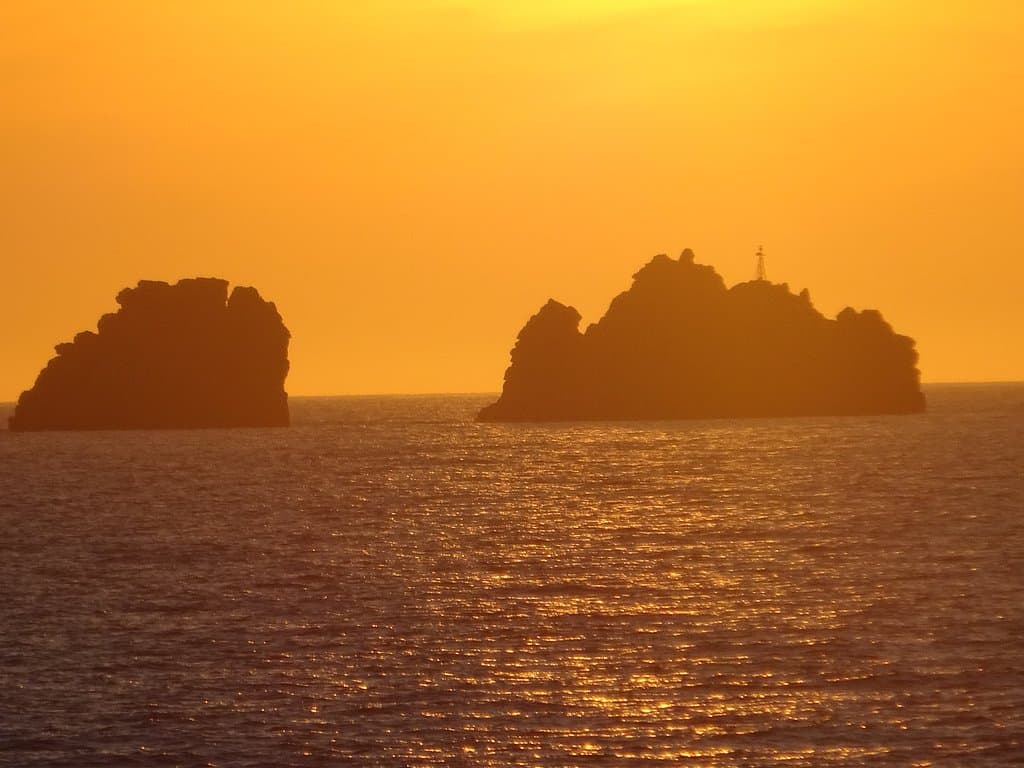 Admiring the sunset behind the iconic rocks "Portes" (Doors) just outside Parikia Bay - Paros, Greece
