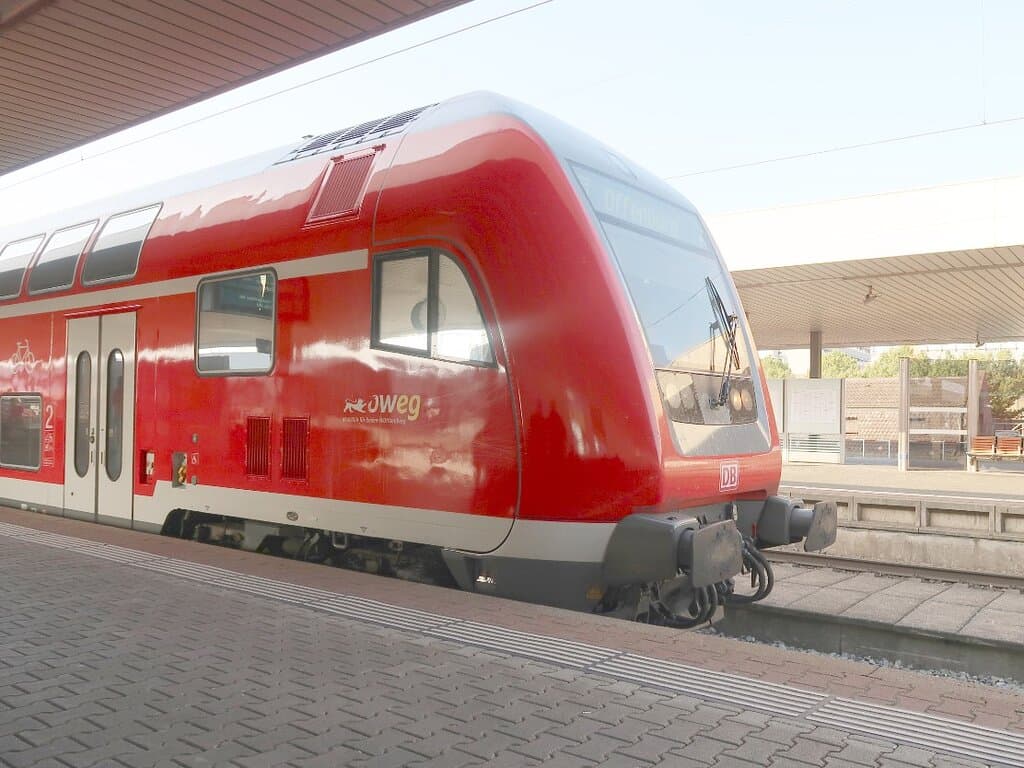 Typical DB train with red color body with white stripe entering the platform