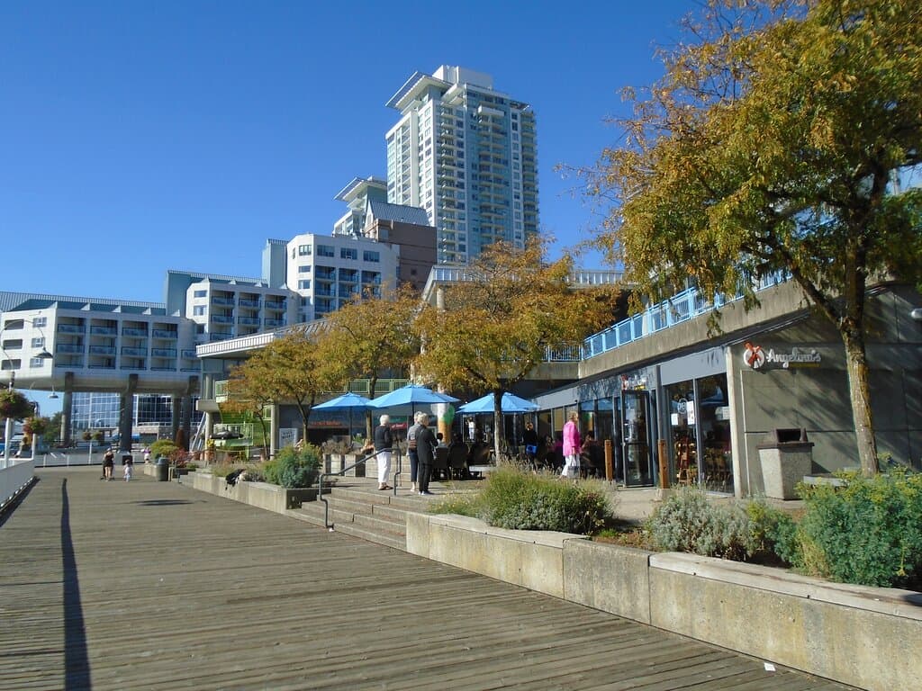 The market from the Quay - note umbrellas and people near food area. Hotel in background. Also note dearth of people on boardwalk.