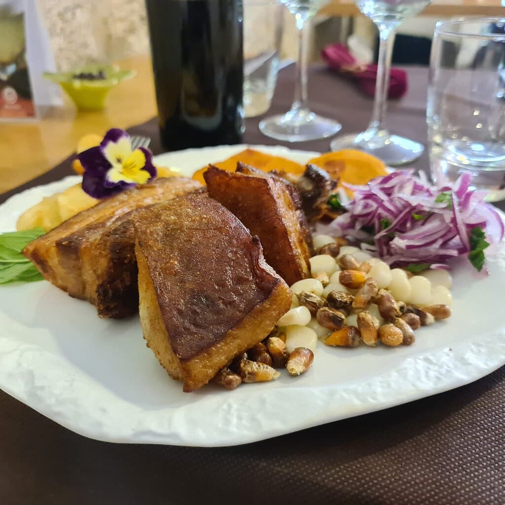 Chicharrón de cerdo al estilo Perú acompañado de camote frito 
(boniato) yuca fritas canchita chulpi  choclo y cebolla roja en sarza.