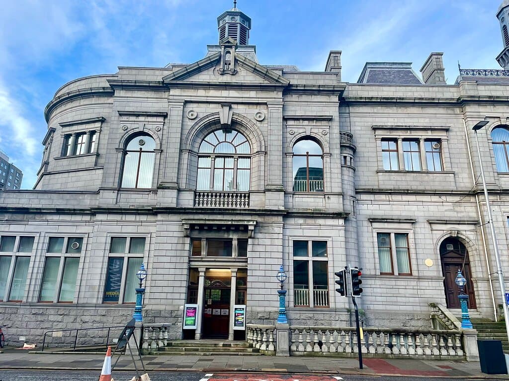 This beautiful Neo-Renaissance building with it’s fine granite edifice was designed by architect Alexander Brown in 1892, and built with public funds, including a large donation from steel magnate Andrew Carnegie ( who opened it.) It has a striking balustrade of ornate detailed iron lamps above the pavement , that were cast by the William MacFarlane’s Saracen Foundry in Glasgow. The stained glass window and staircase are worth seeing too.