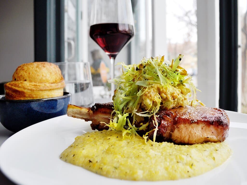Pork chop with herbed goat cheese polenta, braised endive and apple mustard.