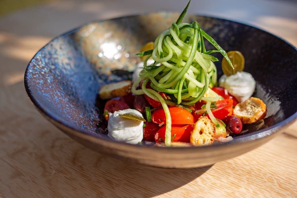 Greek salad with cherry tomatoes served with Galotyri cheese and crispy sesame breadsticks 