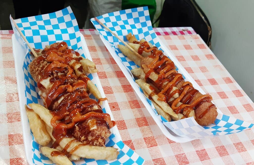 2 Salchichucas con patatas fritas aderezadas con catsup y aderezo Chipotle.