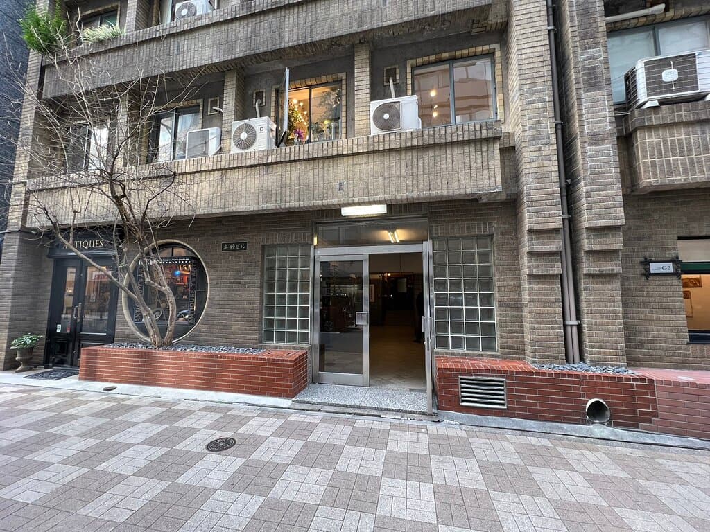 銀座の1932年建築の歴史的ビルです。青山アパートメントを設計した同潤会の川元さんが設計した当時の高級アパートメントで、日本最古の住居用エレベーターがあり、今でも手動ドアで、鉄の蛇腹のゲートが使われております。 階段も昭和初期の佇まいを残しており、階段も豪華な御影石、手すりも無垢の木材を使っています。  アールデコの影響を受けて、丸窓が印象的なアンティークショップやギャラリーなどのたくさんお店が入っております。