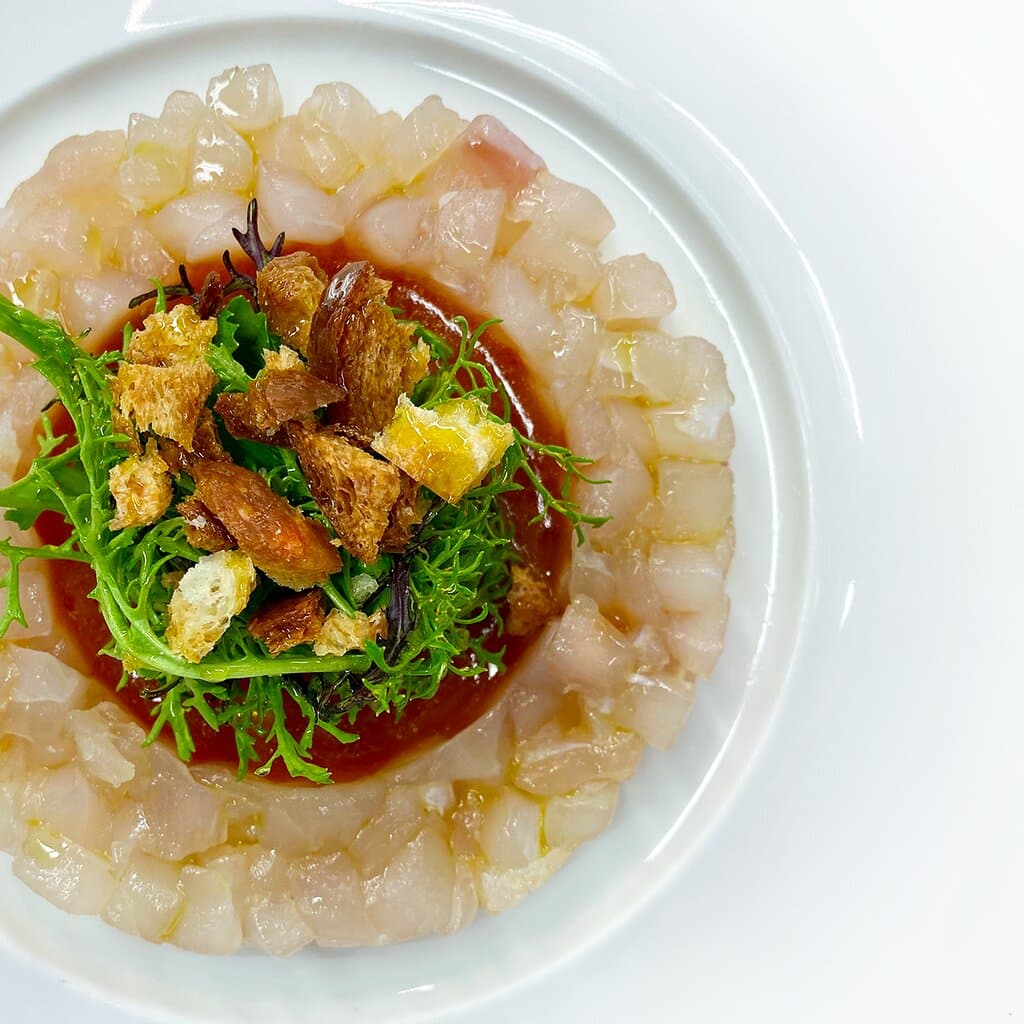 Crudo di dentice reale nostrano, salsa all'acqua pazza con capperi di Pantelleria, olive taggiasche e pomodoro del Piennolo.