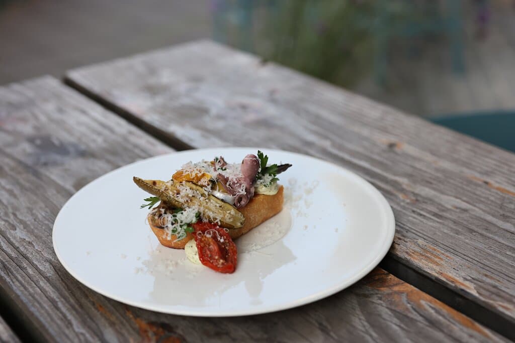 Focaccia & Pestofrischkäse mit Pecorino, Grillgemüse, Krake und Sardine  - ein Zwischenganz von der Restaurantkarte