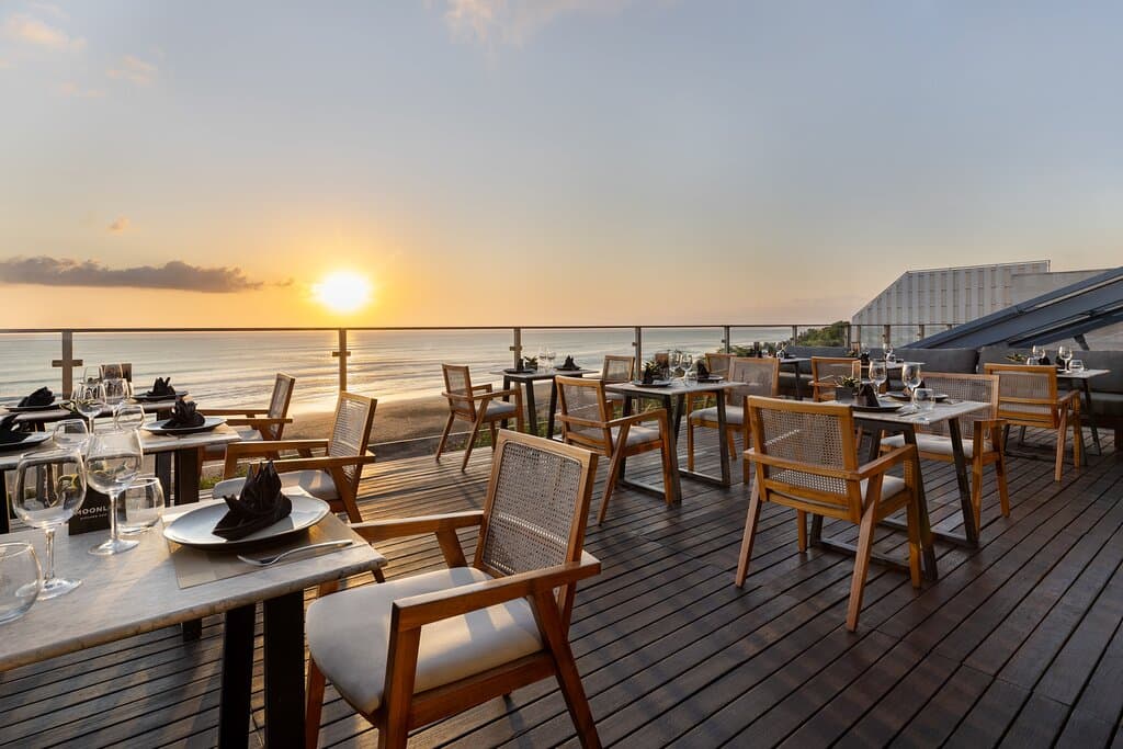 Savor your meal under the open sky, overlooking the stunning Seminyak Beach sunset.