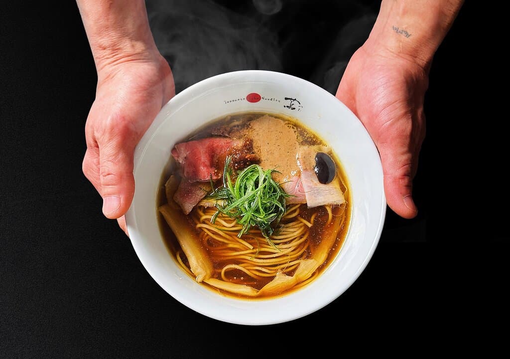 Shoyu Soba This ramen is a testament to the harmonious marriage of Japanese and Western culinary influences, expertly curated within a single bowl. Each element in this dish embodies the fusion of diverse cuisines: the four seasons of Japanese culinary tradition, the delicate textures of Chinese cuisine, the flavorful accents of Italian cooking, and the layered complexity of French gastronomy. 