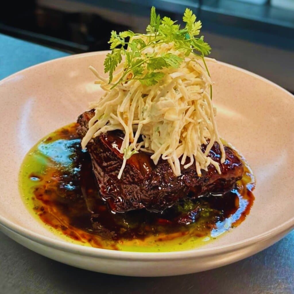 12 Hour Braised Short Rib with chimichurri, celeriac, fresh green leaves, and remoulade.