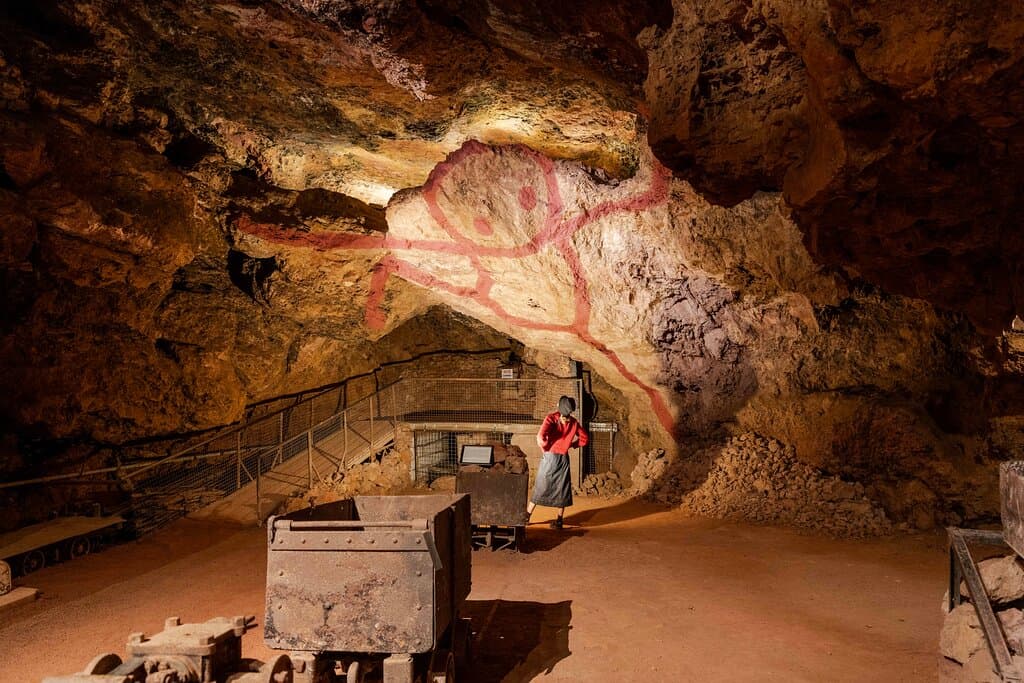 Internationally renowned artist STIK used 4.5kg of ochre hand-mined from Clearwell Caves (enough to paint a house!) to create 'The Ochre Man' in 2022 — a permanent contemporary cave painting.