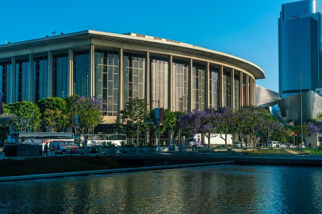 Dorothy Chandler Pavilion reflected in pools surrounding Power and Light Building across the str