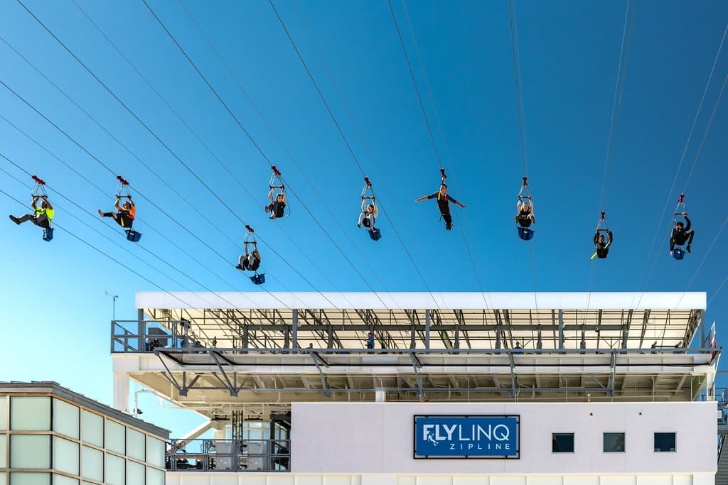 Riders flying down the FLY LINQ Zipline.