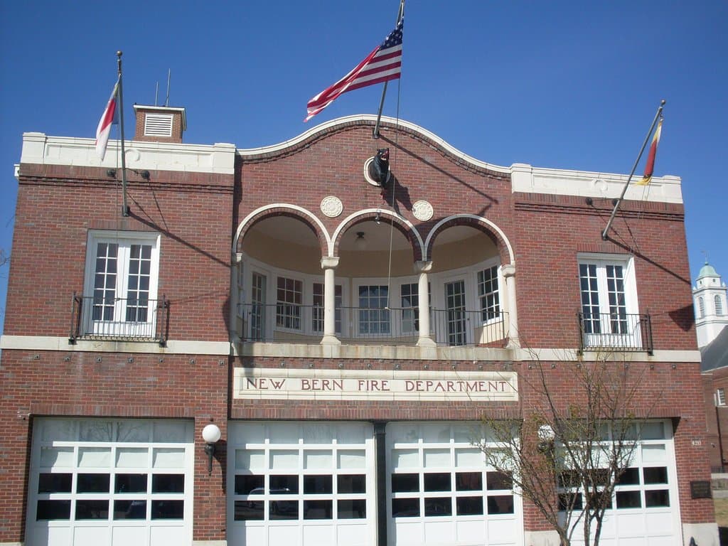Outside shot of the firehouse with the New Bern symbol (the bear) just below the flag.