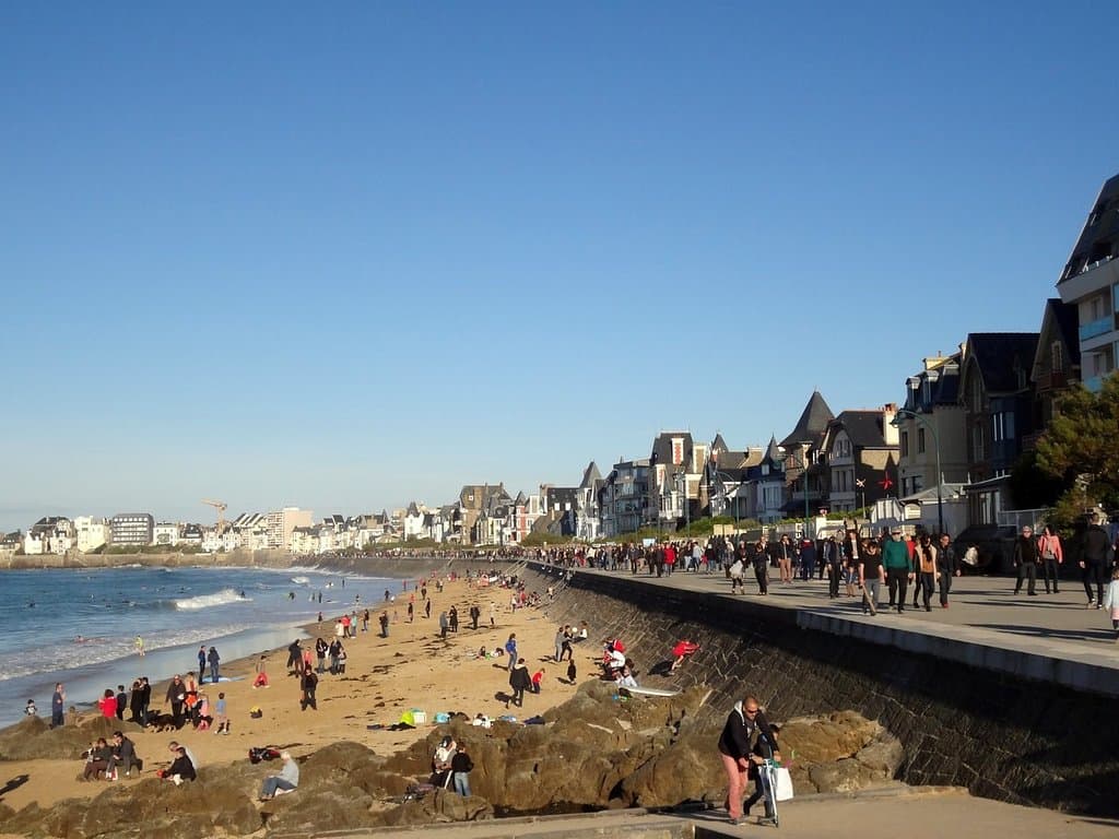 Foule de touristes sur la digue et sur la plage, par marée haute, au niveau de la plage de La Hoguette