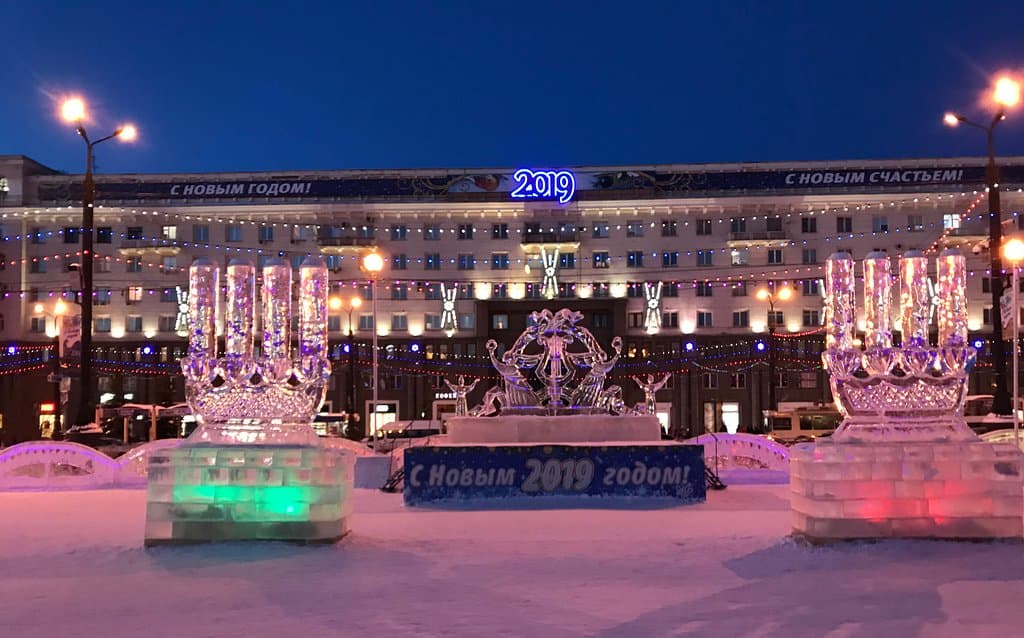 Ночная подсветка центральной улицы на площади, блеск ледяных скульптур.