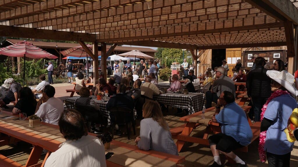 View of community members sitting in the Pavillion. Taken at the 2022 Raise the Farmhouse! event.